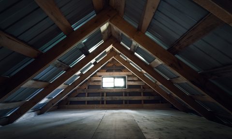 Empty attic with wood floor and small window