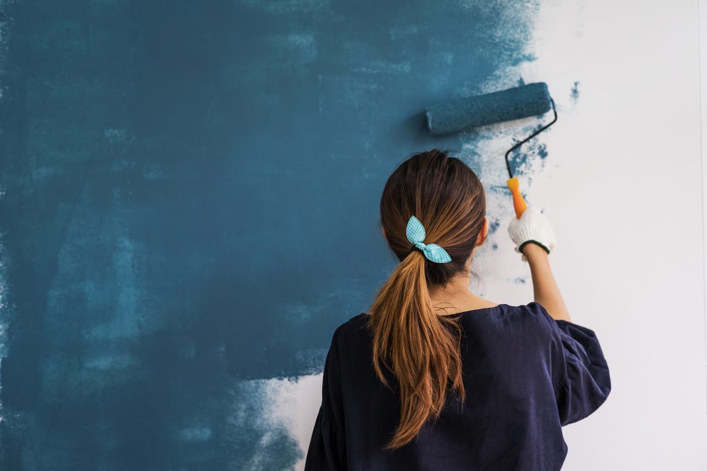 Woman painting with paint roller