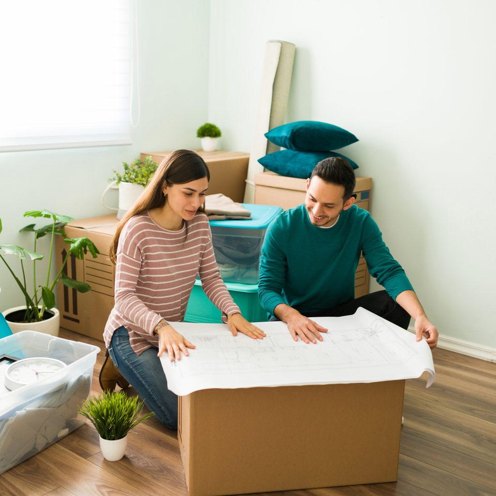 Happy couple looks at bedroom renovation plans
