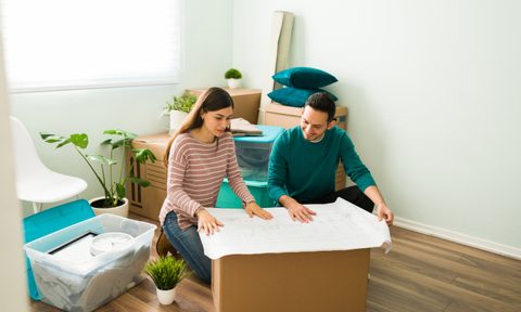 Happy couple looks at bedroom renovation plans