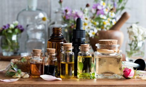 essential oils in small jars with flower decor