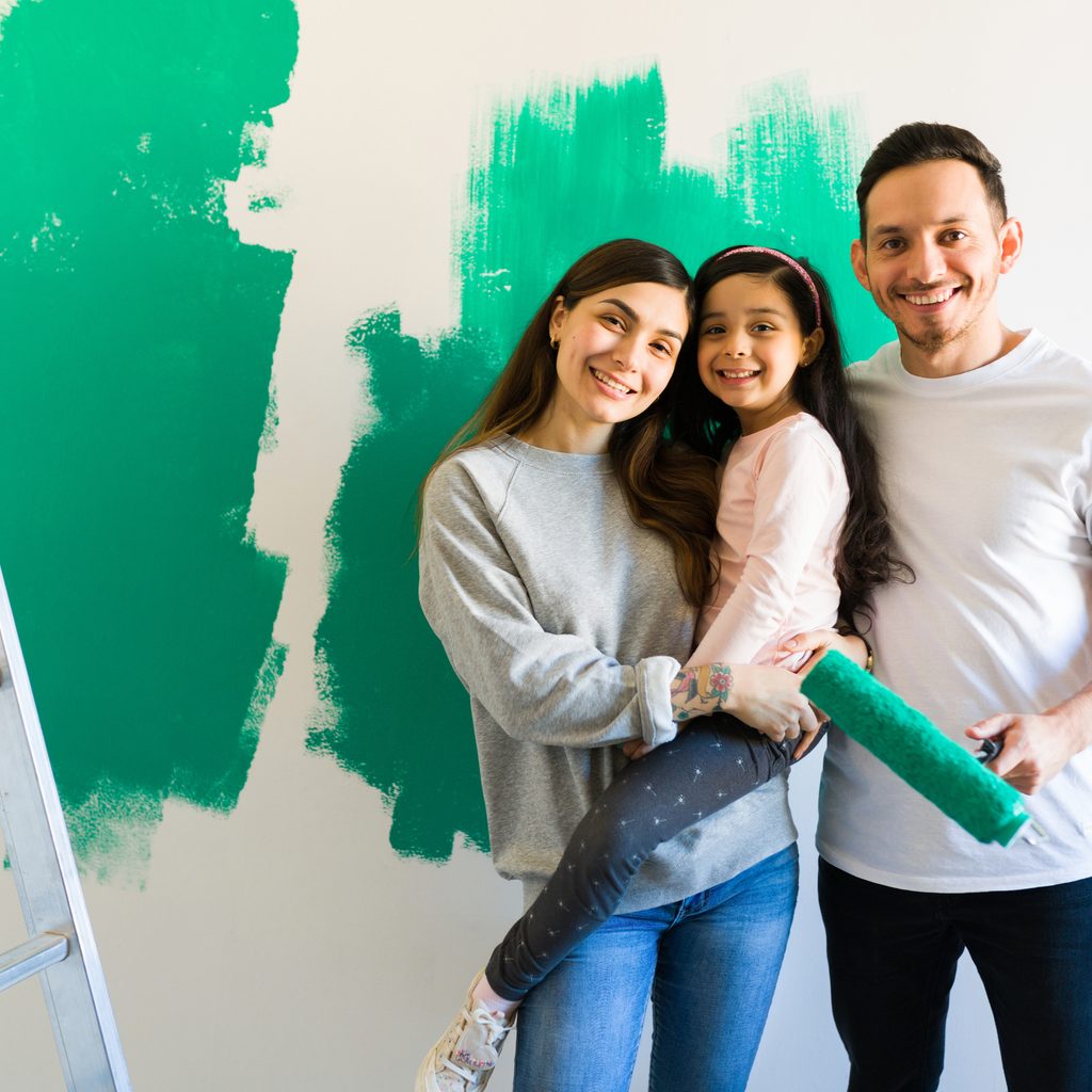 Family poses beside painted wall