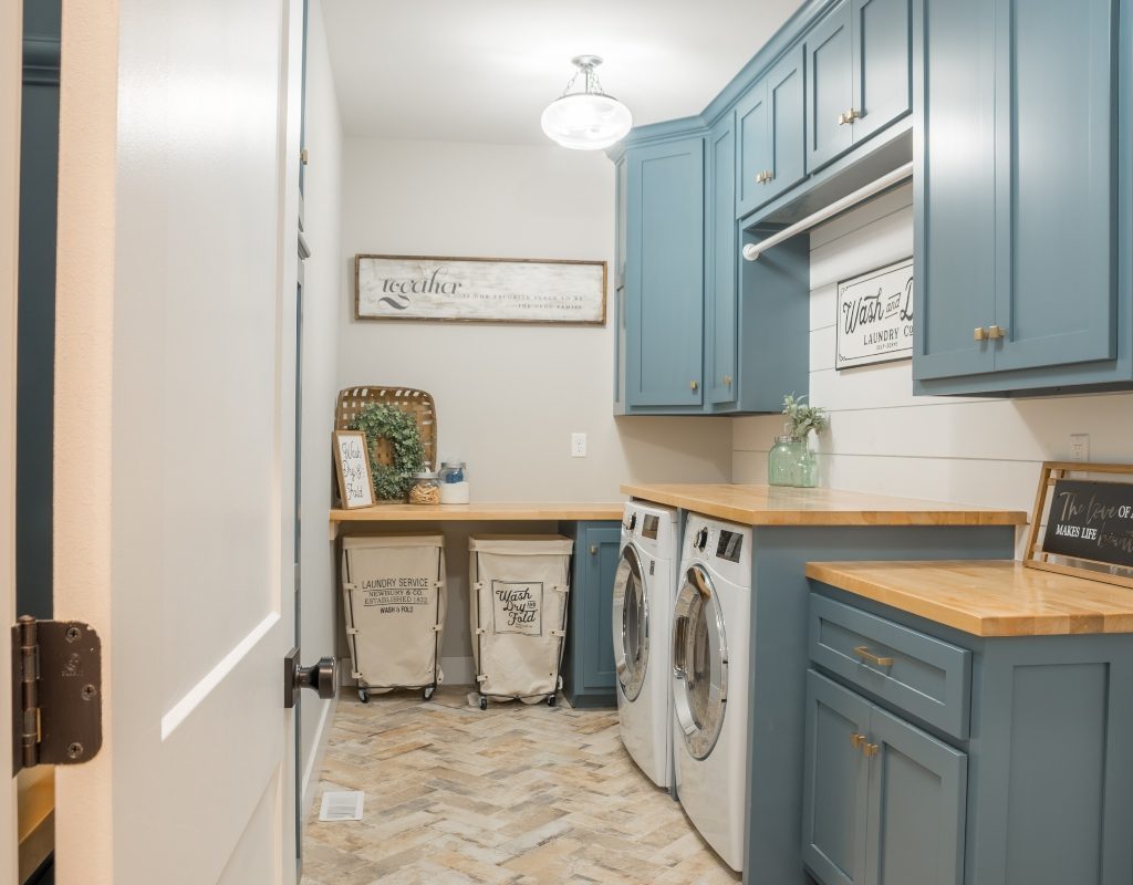 Well lit laundry room with blue cabinets