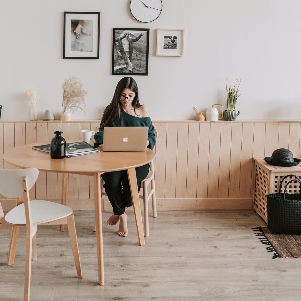 Minimalist kitchen with woman seated at table