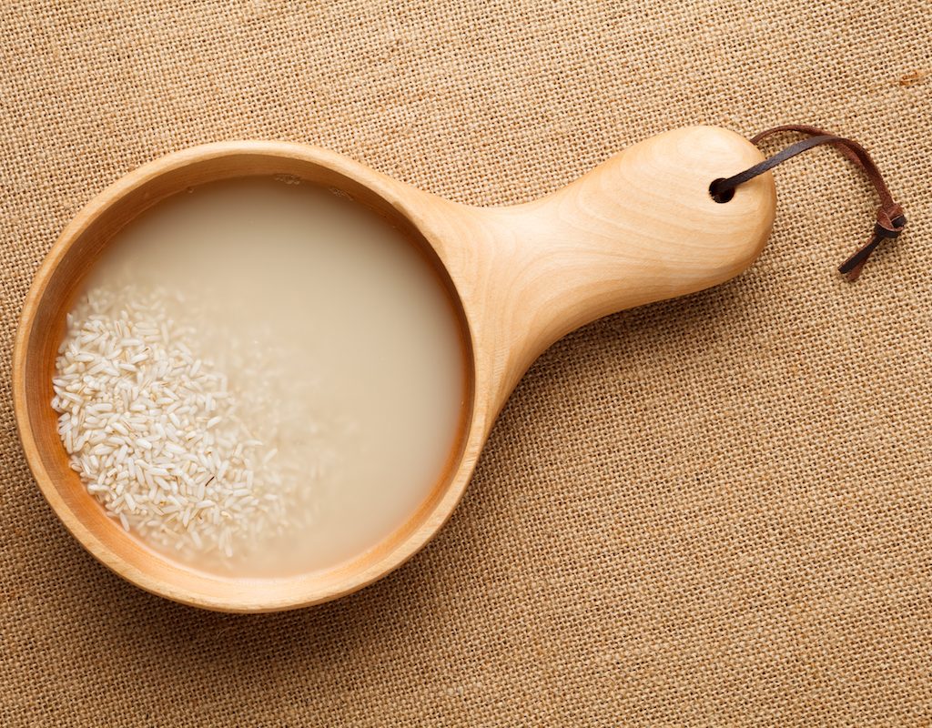 Washing rice in a wooden bowl