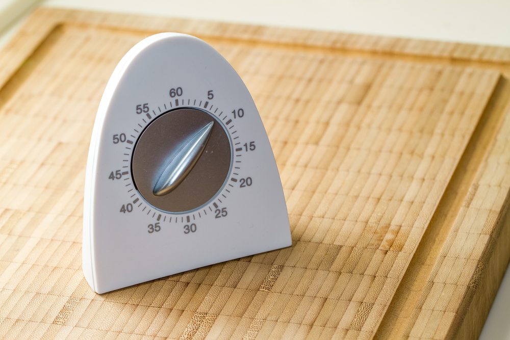 white curved kitchen timer on wood countertop