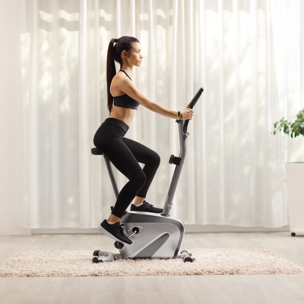 Young woman riding stationary bike