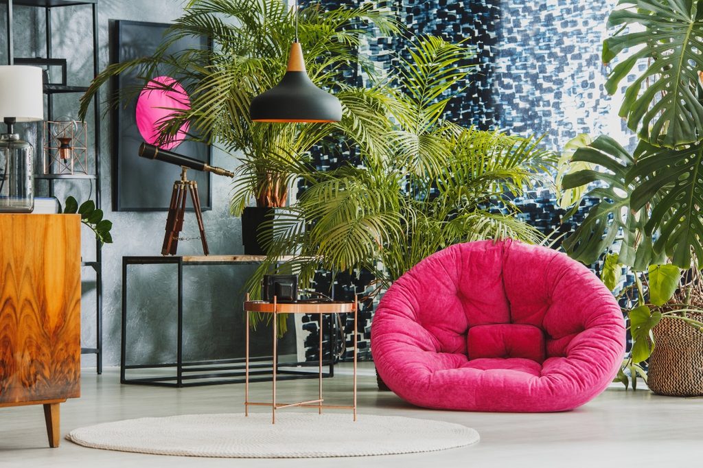 bright pink chair and printed wall art in maximalist room