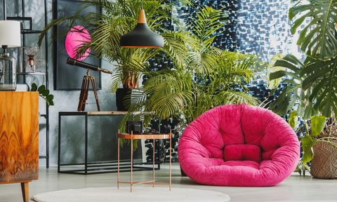bright pink chair and printed wall art in maximalist room