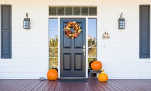 Fall wreath and pumpkins on front door on porch