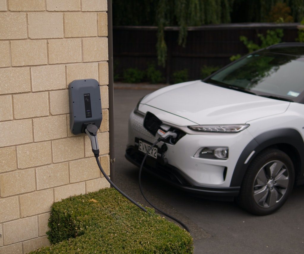 electric vehicle connected to charger on brick wall