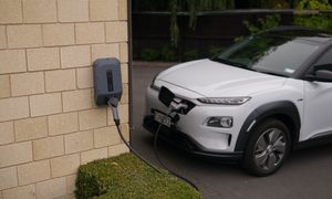 electric vehicle connected to charger on brick wall
