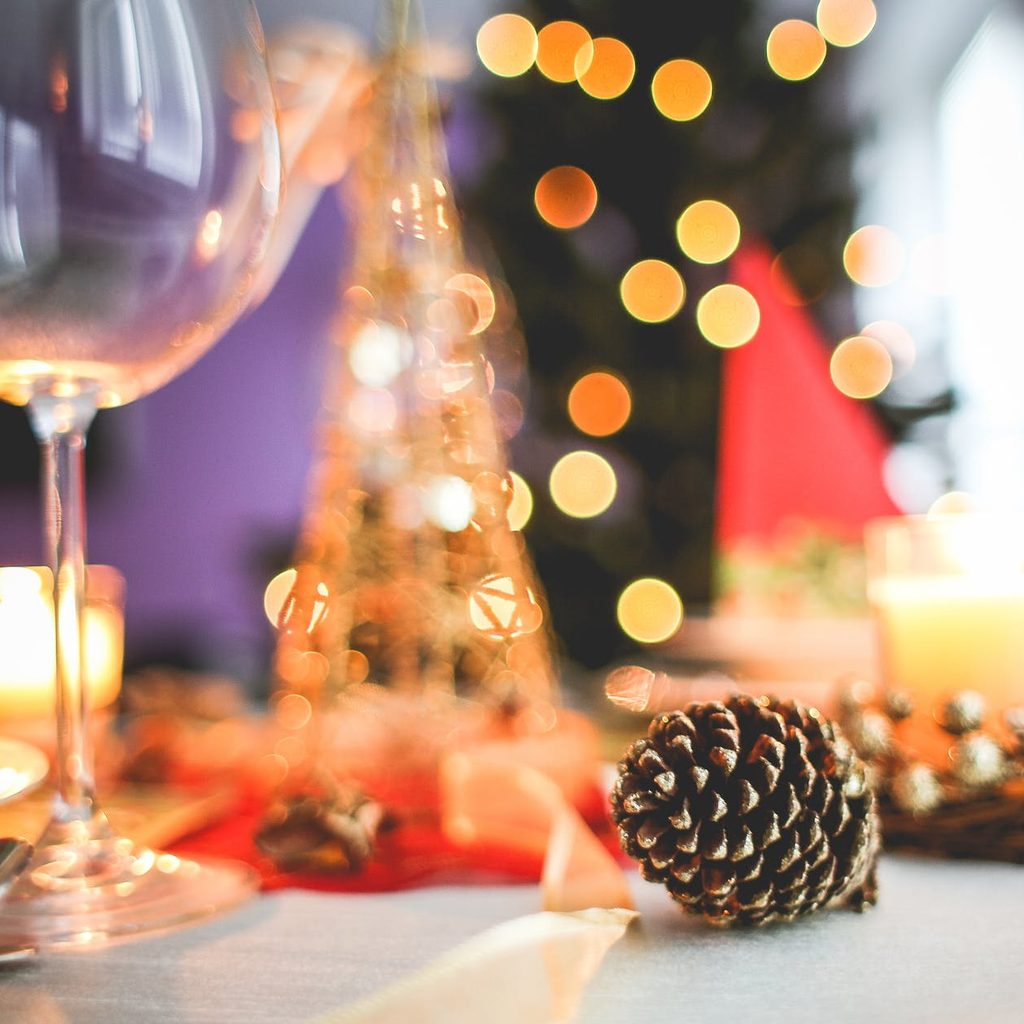 Holiday party with wine glass and pine cone