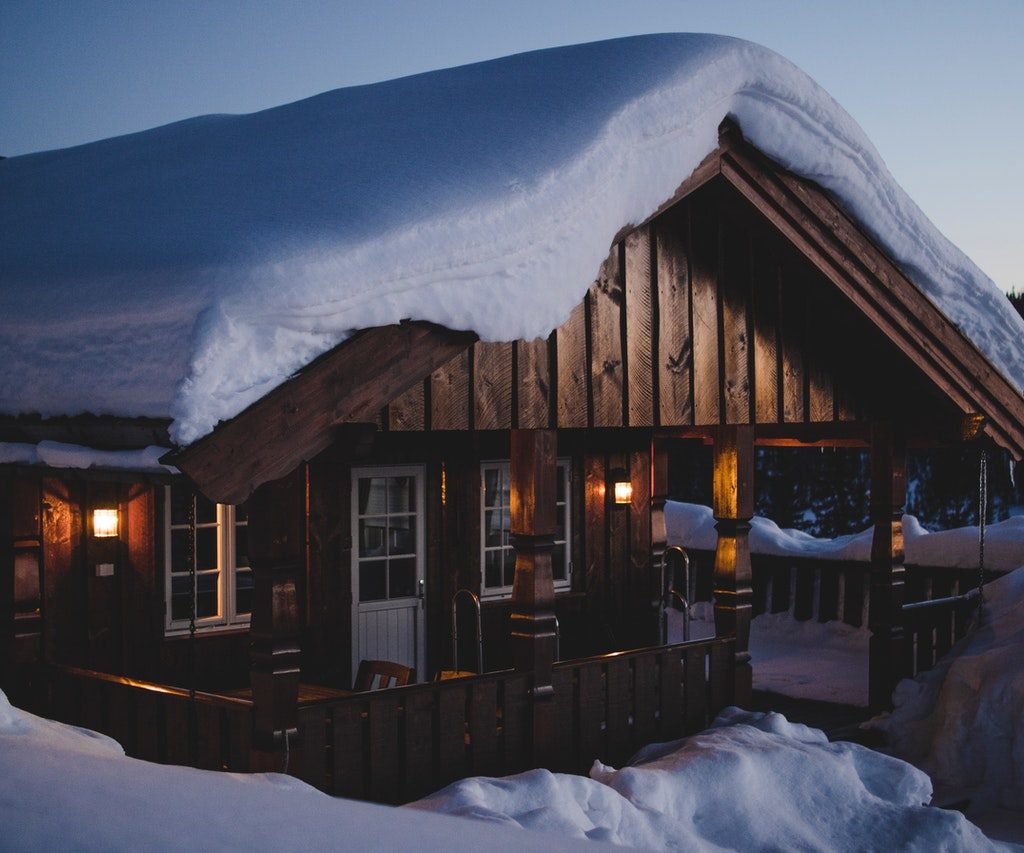 Remote wooden house with heavy snow
