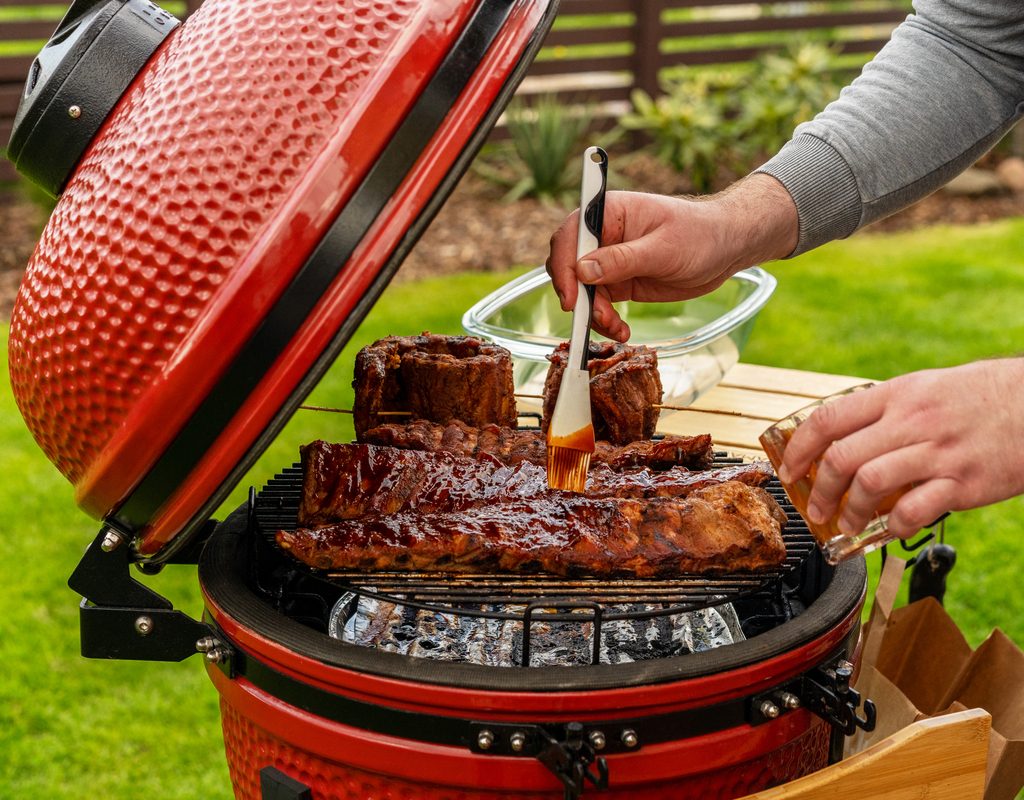 Man cooking with small red grill
