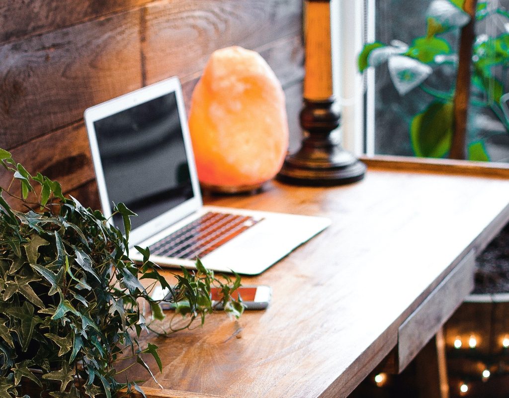 Himalayan salt lamp and plants on office desk