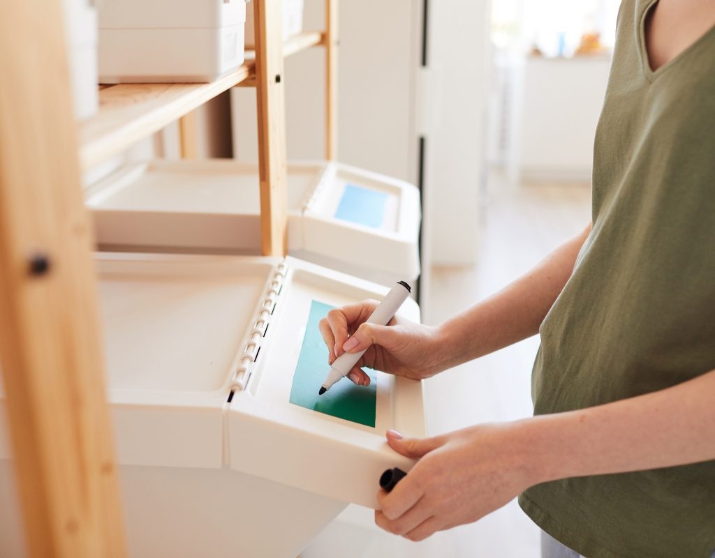 woman writing labels for storage bin