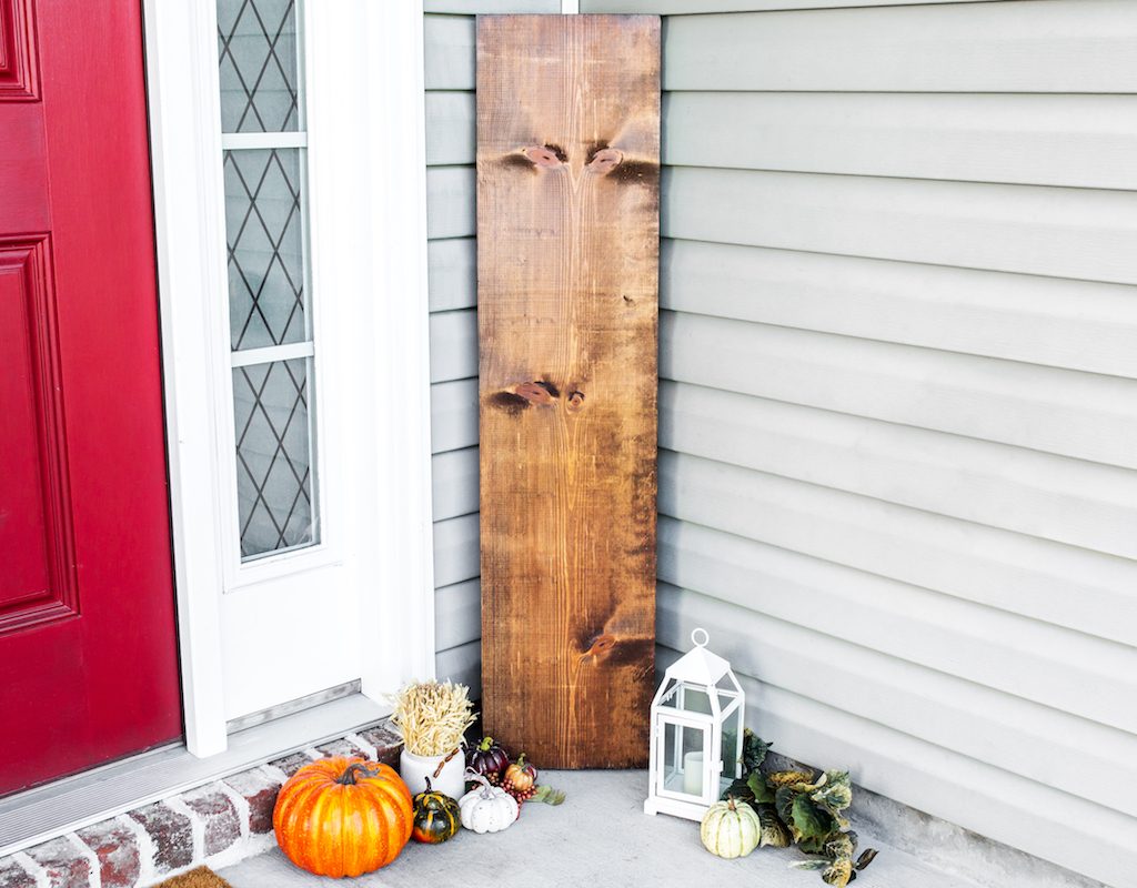 fall wood sign by front door with pumpkins