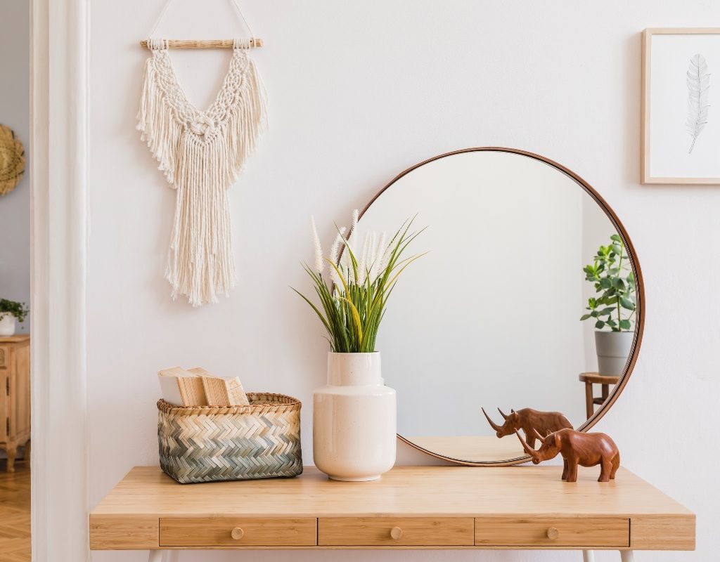 Mirror and green plant on an entryway table