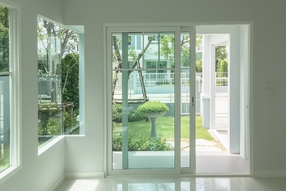 Sliding glass patio door with white trim, walls, and floor