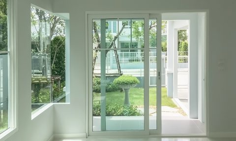 Sliding glass patio door with white trim, walls, and floor