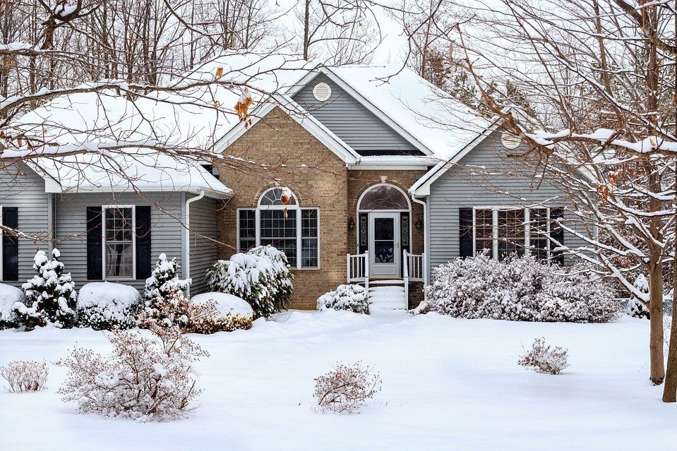 house with vinyl siding and brick in winter