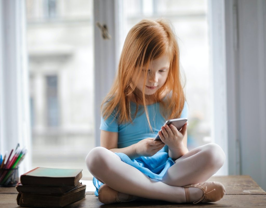 young girl playing on iphone