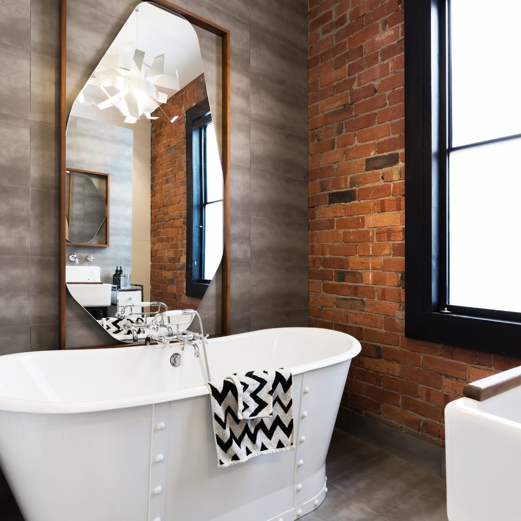 bathroom with tile and brick wall
