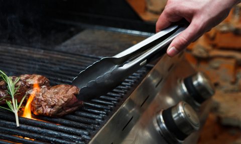 Using tongs on a gas grill