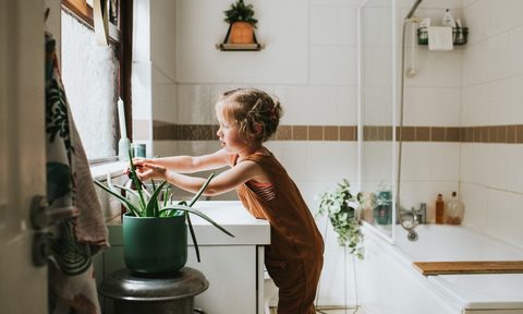 small child washing their hands in a neutral designed bathroom sink