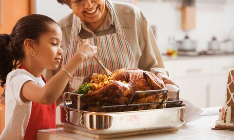 Grandmother helping child with Thanksgiving turkey