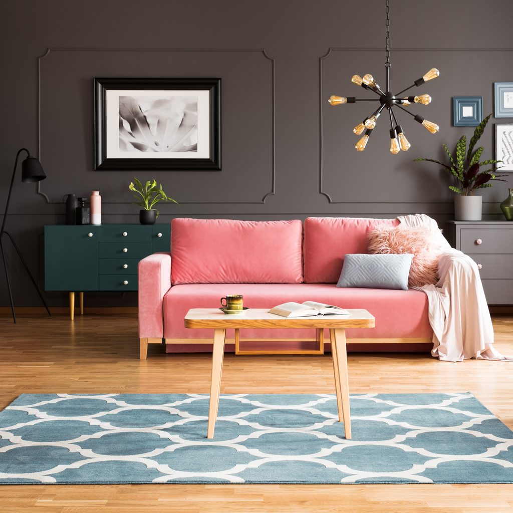 gray living room with pink sofa and blue rug