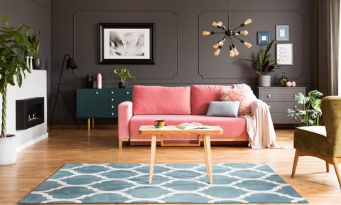 gray living room with pink sofa and blue rug