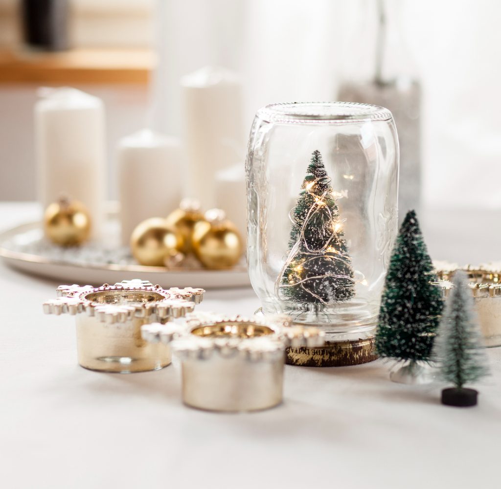 Modern christmas decorations with candles, bulbs, and small trees.