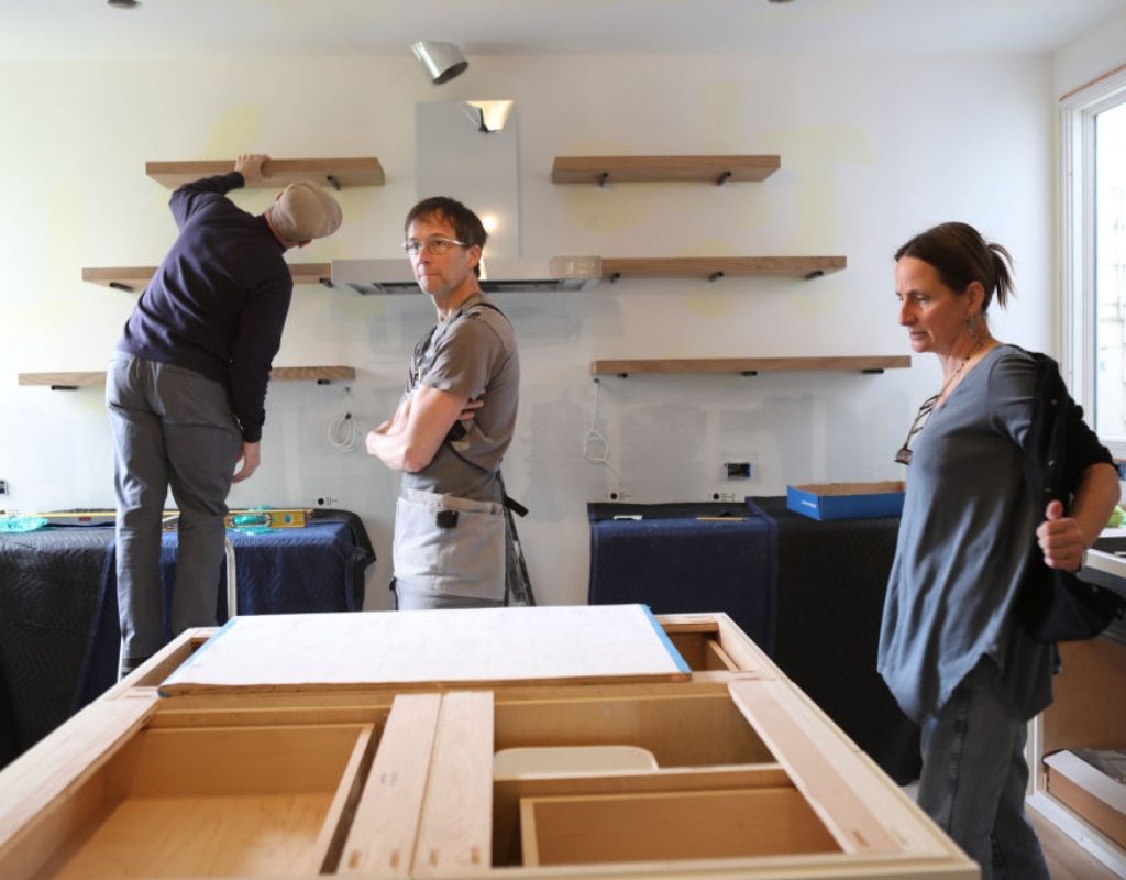 People renovating the kitchen and replacing the cabinets
