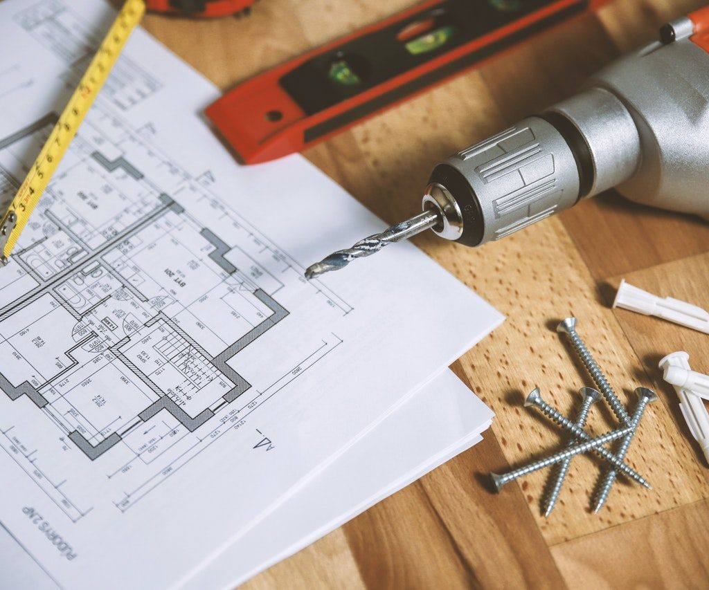 Floorplan and tools on wooden surface