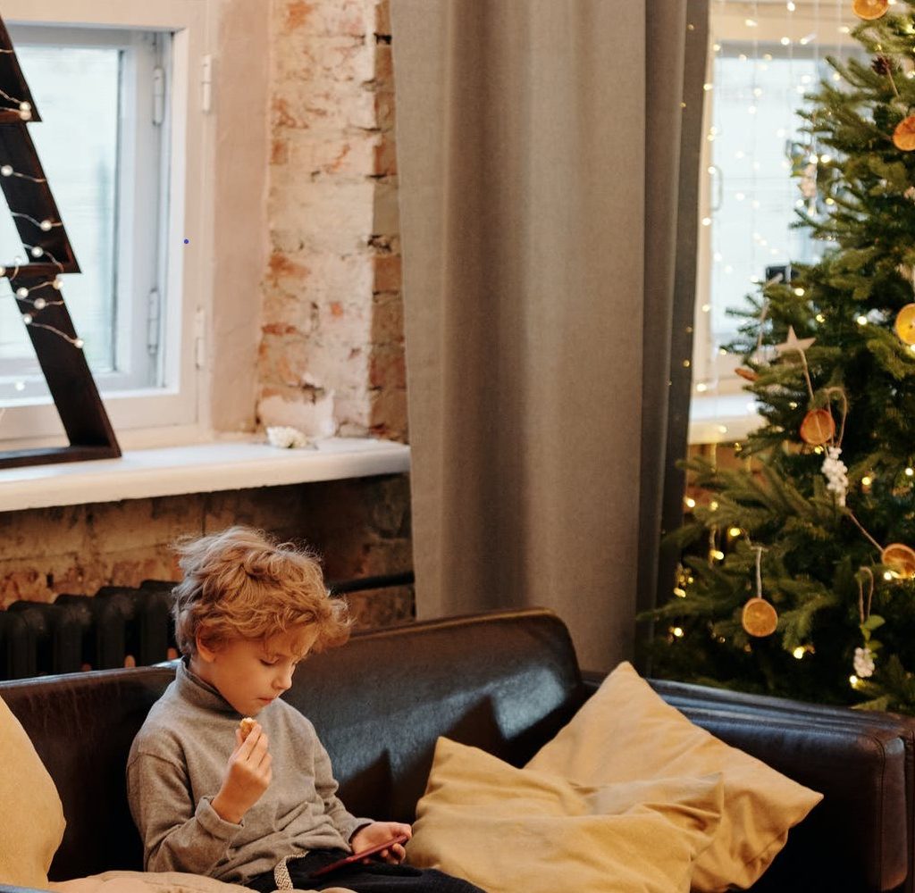 child on couch – Christmas tree