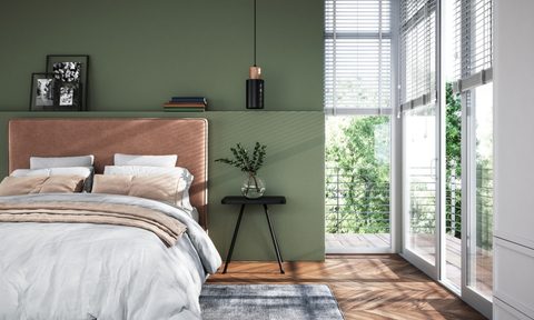 decorated modern bedroom with green walls and plants