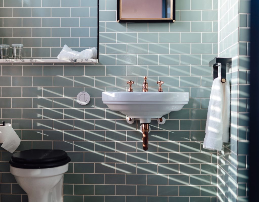 small bathroom with blue tiles and floating sink