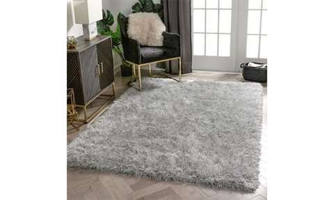 Well Woven Kuki Chie Glam Solid Textured Rug placed on a living room floor.