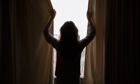Woman closing blackout curtains