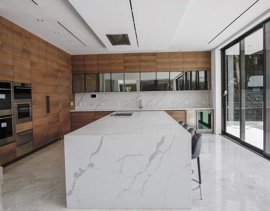 midcentruy modern kitchen with wood cabinets and marble iland