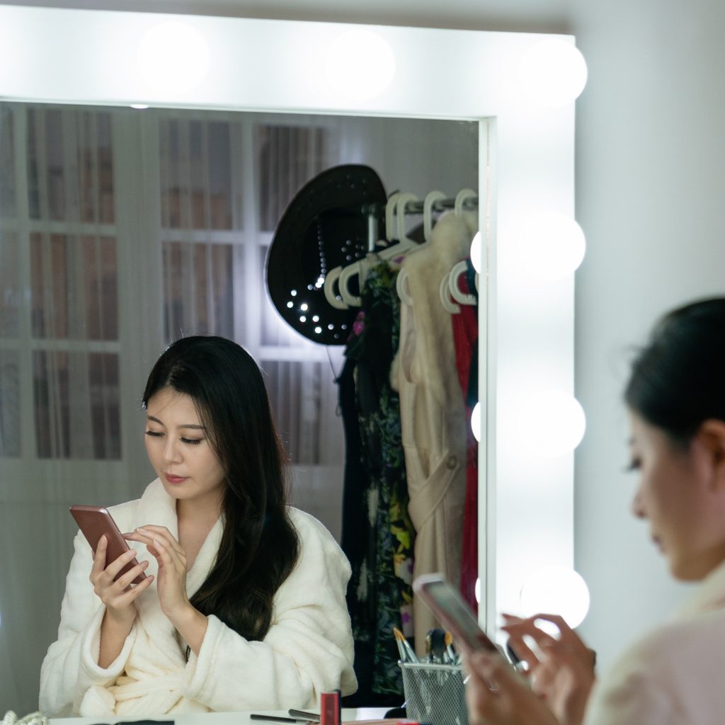 Young woman sitting at a vanity in a walk-in closet