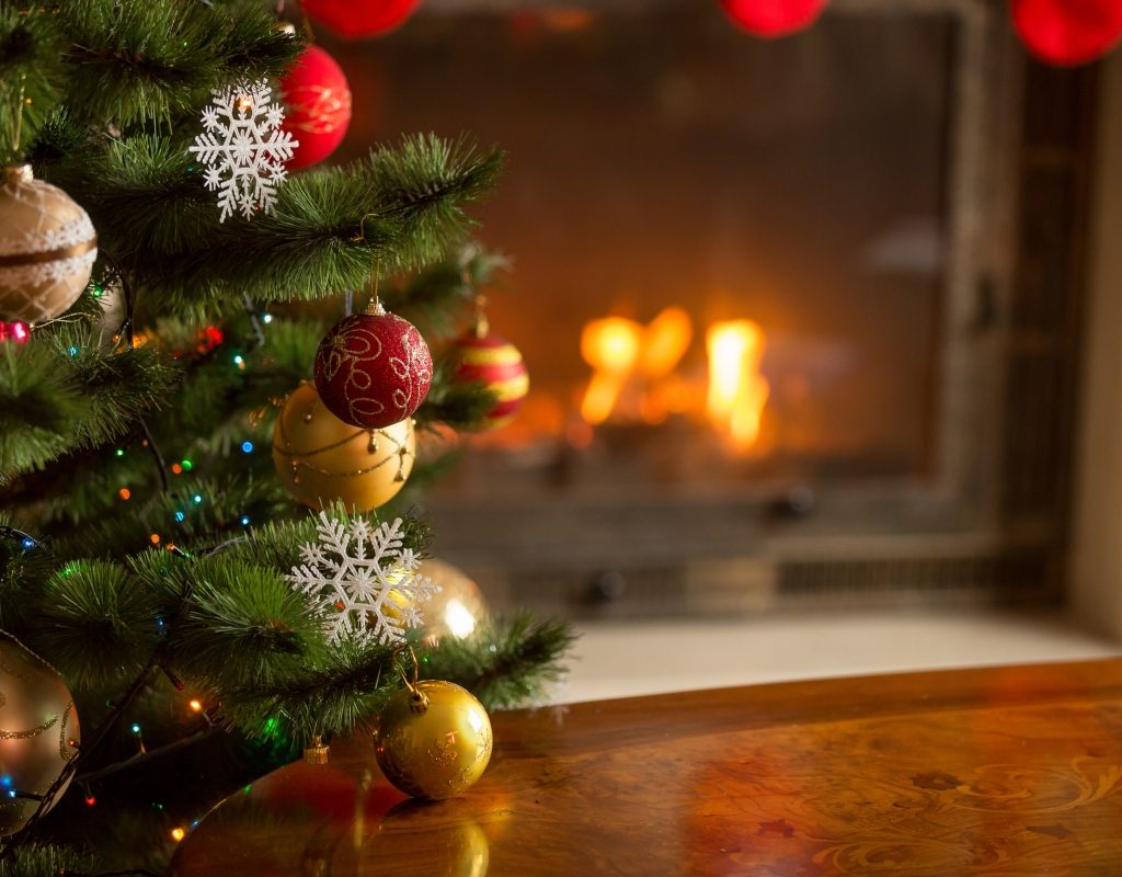 Close-up of Christmas tree ornaments in front of fireplace