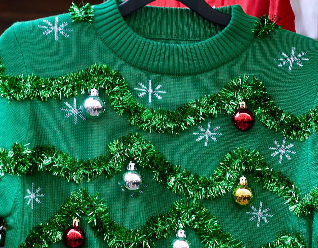 Green ugly Christmas sweater on hanger