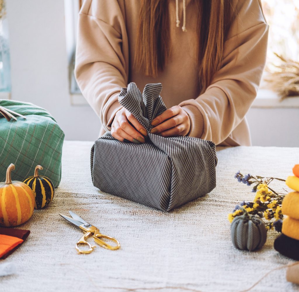 Person wrapping gifts in blankets instead of wrapping paper.