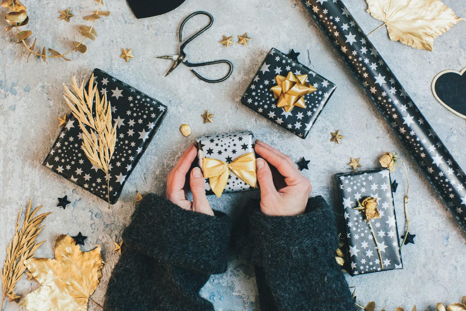 Person wrapping gifts with bows.