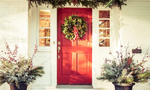 Red front door with winter wreath and garland