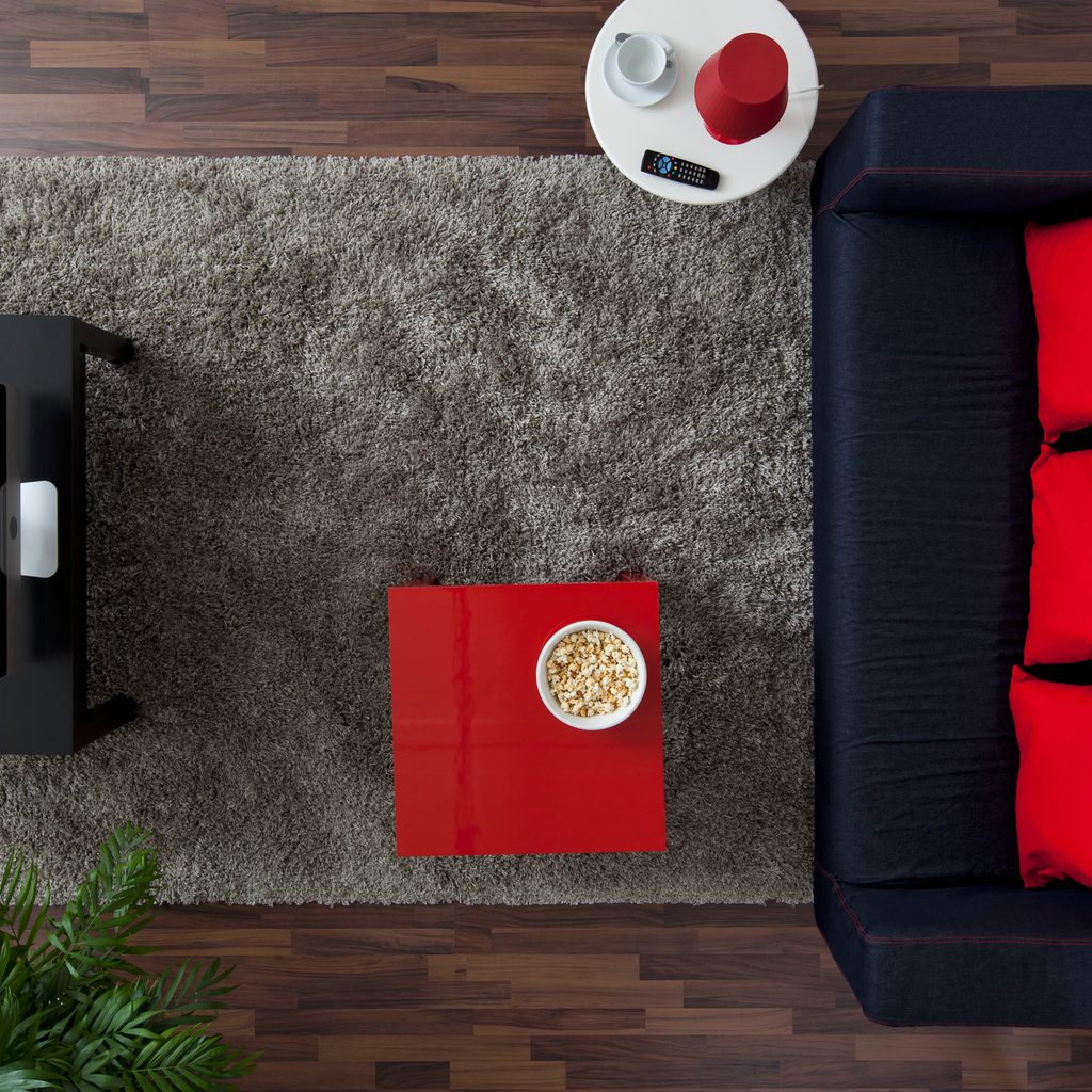 An overhead view of a living space with a rug under the furniture.