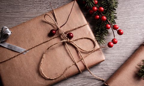 Christmas gift wrapped in brown paper with cranberries
